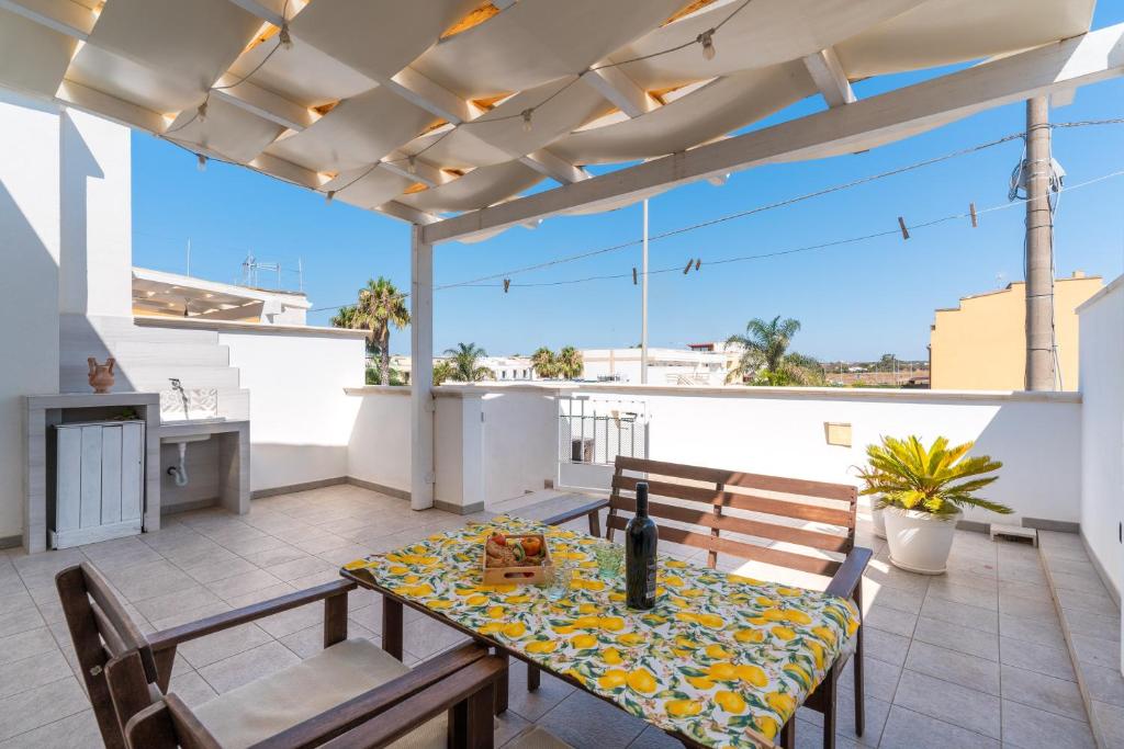 a patio with a table and chairs on a roof at Donasand_torre san giovanni in Torre San Giovanni Ugento