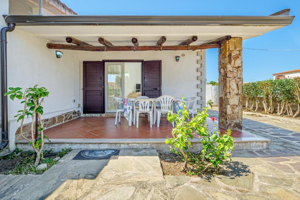a patio with a table and chairs on it at Confortevole villetta caposchiera in San Teodoro