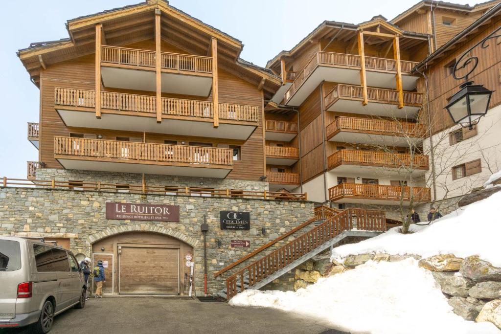 a building with a parking lot in front of it at Appartement B56 - Eco Le Ruitor in Sainte-Foy-Tarentaise