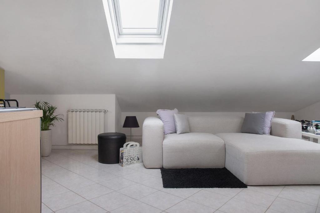 a white couch in a living room with a window at Mansarda Massimo - Verbania Intra in Verbania