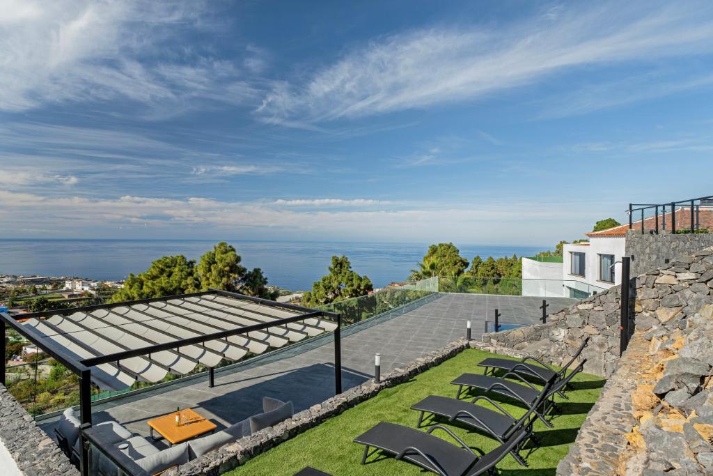 an outdoor patio with chairs and a view of the ocean at Buena - Vista in La Guancha