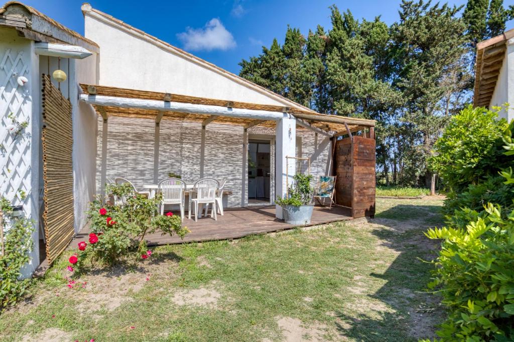 a patio with a table and chairs on a house at Mas des Cypres - Mazet 5 in Saintes-Maries-de-la-Mer