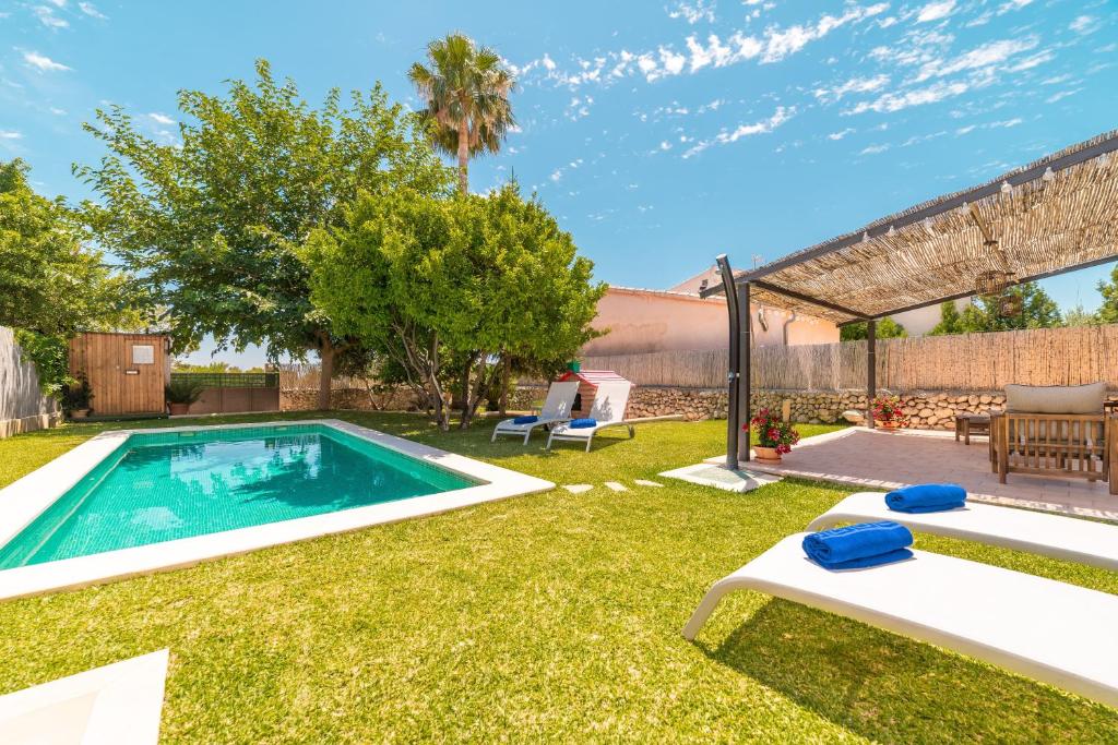 a backyard with a swimming pool and grass at Villa Ca Na Campins in Campanet