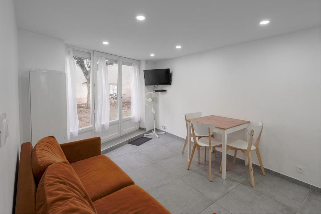 a living room with a couch and a table at Appartement dans maison atypique in Montrond-les-Bains