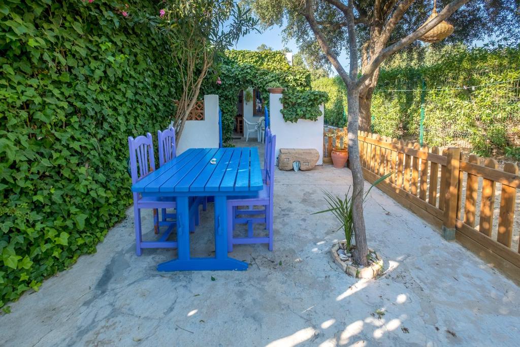 a blue picnic table with two chairs next to a tree at Casa de Gertrudis in El Palmar