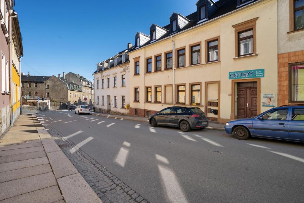 two cars parked on the side of a street with buildings at Haus Berlin Annaberg in Annaberg-Buchholz