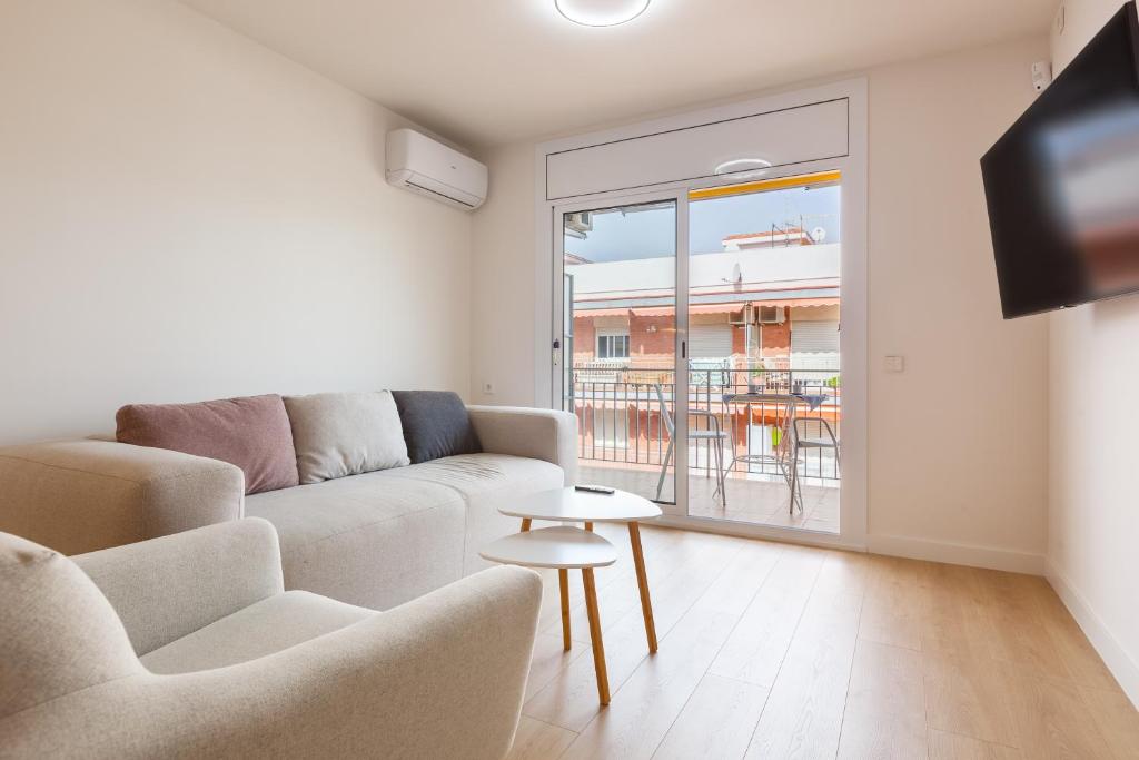a living room with a couch and a table at Blue Coast Apartment in Canet de Mar