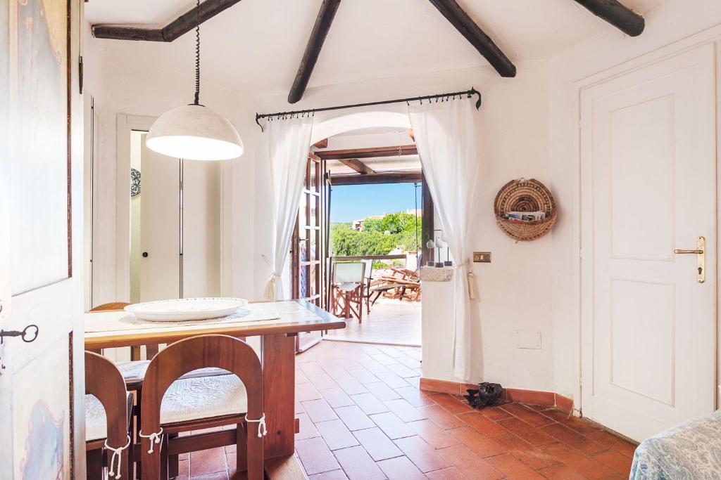 a kitchen and dining room with a table and chairs at Casa Mucchi Bianchi PC33 in Arzachena