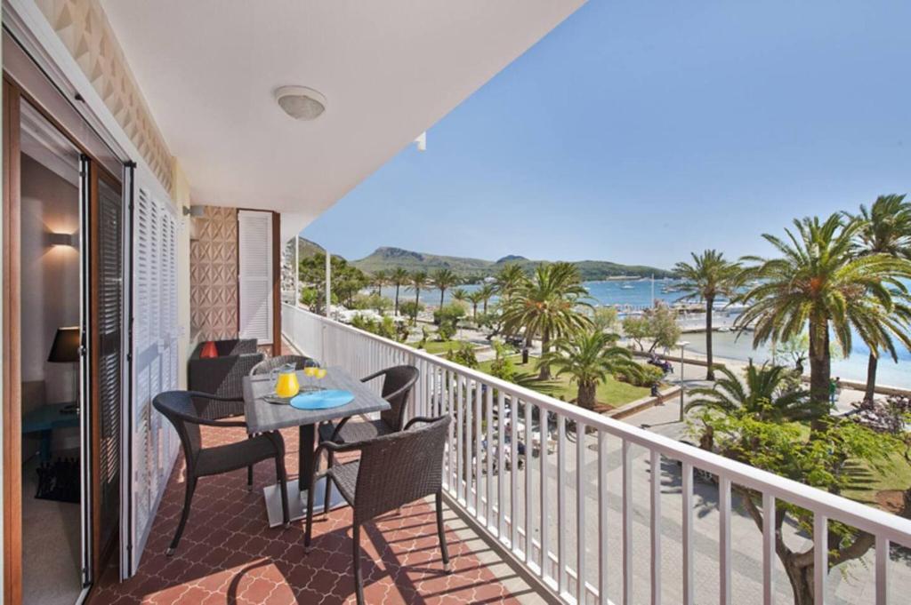 a balcony with a table and chairs and a view of the ocean at Maina 1919 in Pollença