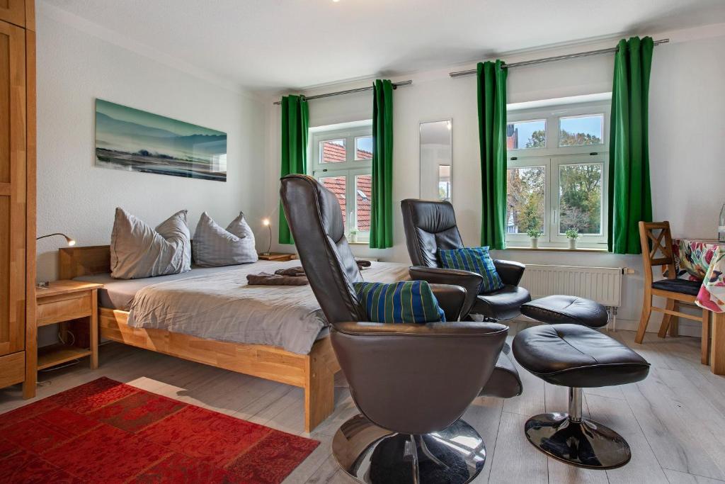 a bedroom with a bed and two chairs and a couch at Bäckerhus - Ferienwohnung 3 in Wiek auf Rügen