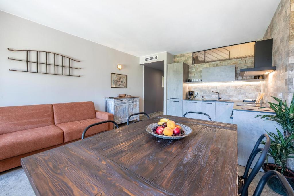 a living room with a wooden table with a bowl of fruit at Abaye 5 Barolo - Charm Adults Only in Soiano del Lago