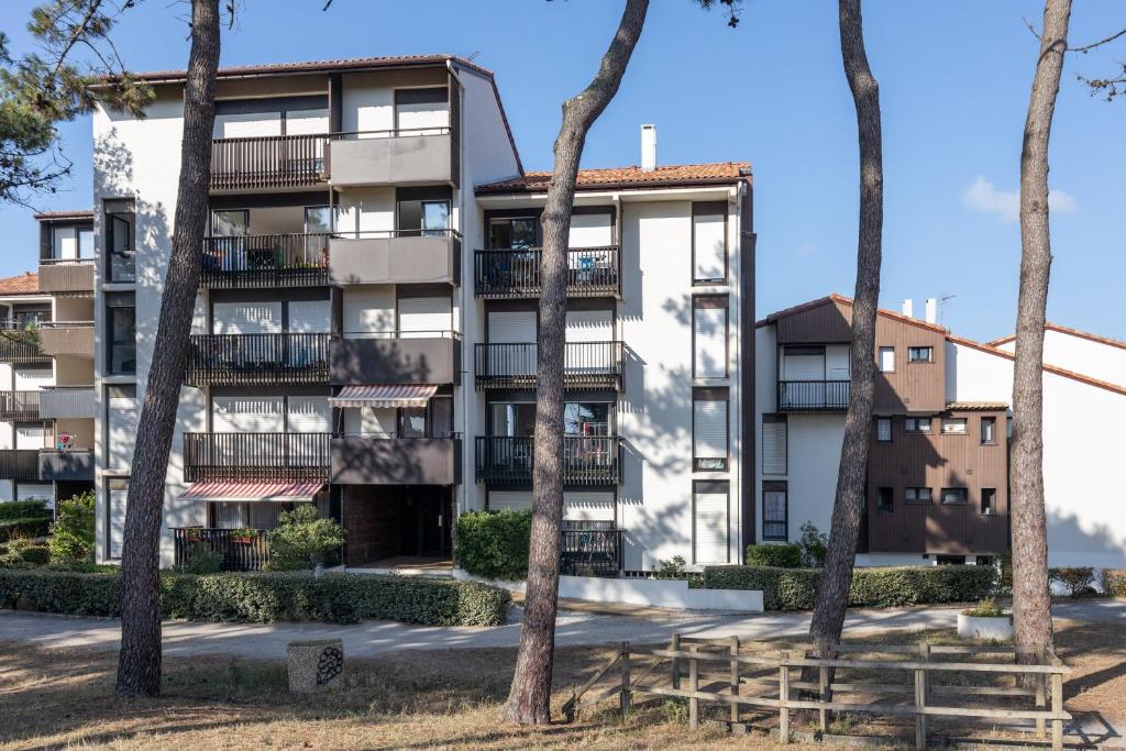 an apartment building with trees in front of it at Location Seignosse Le Penon in Seignosse