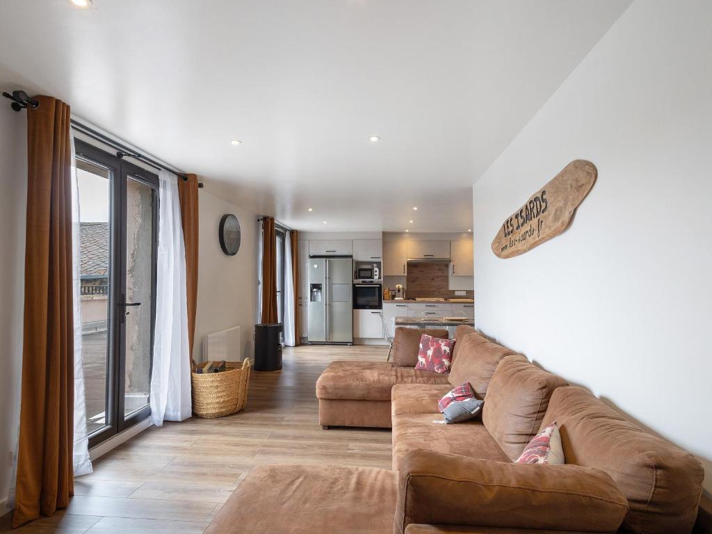 a living room with two brown couches and a kitchen at Residence les Isards in Formiguères