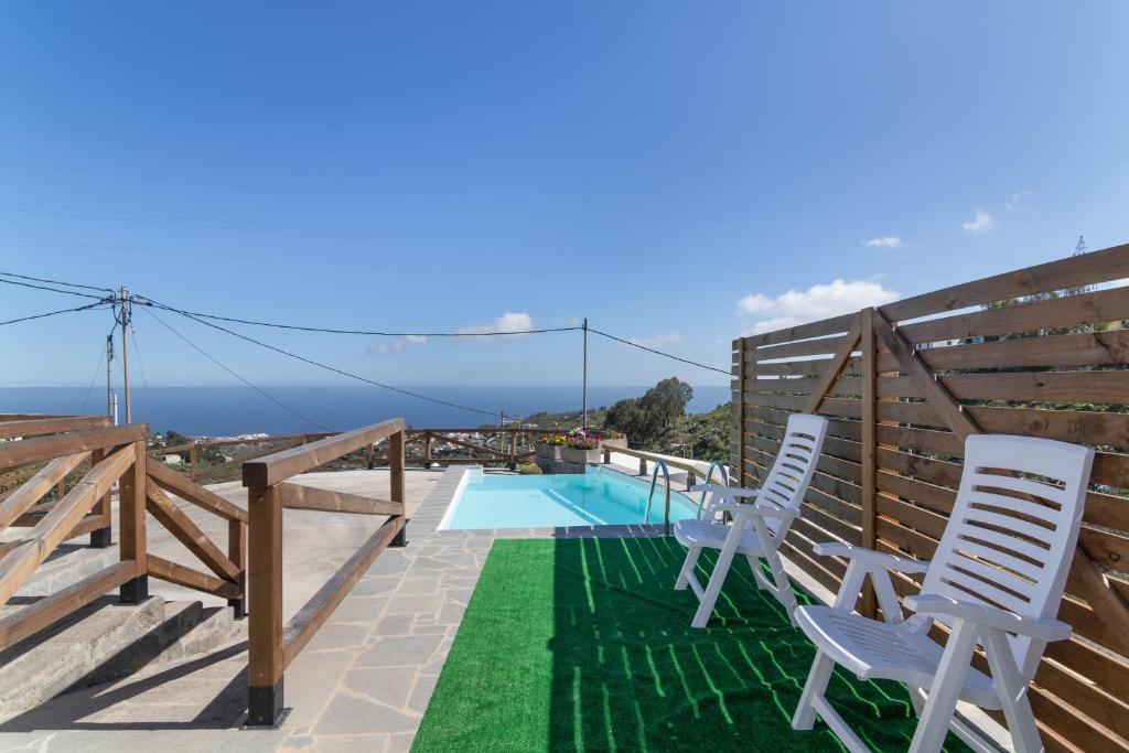 a patio with two chairs and a swimming pool at Los Barranquillos in Las Palmas de Gran Canaria