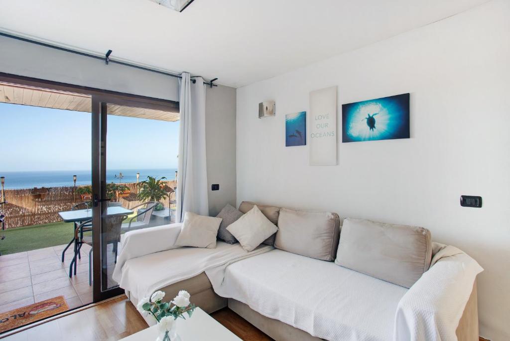a living room with a couch and a view of the ocean at Sunset Apartment in Puerto Rico de Gran Canaria