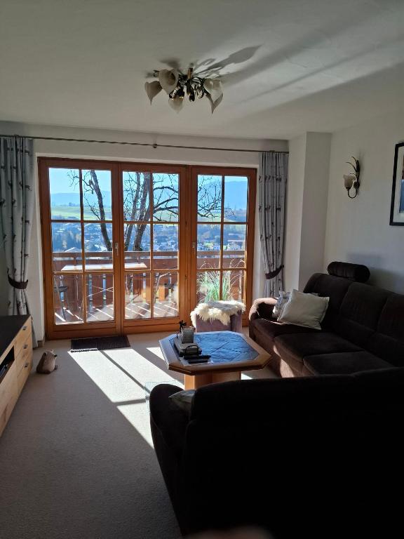 a living room with a couch and a large window at Ferienwohnung Leni in Sonthofen