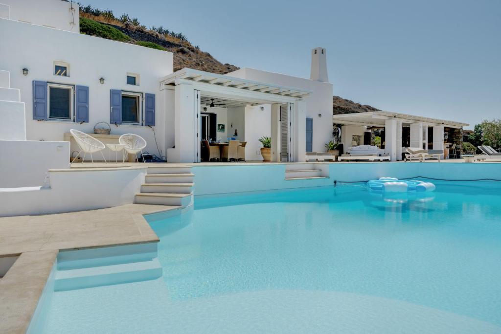 a villa with a swimming pool with blue water at Blueros - Olive suite in Megas Gialos - Nites