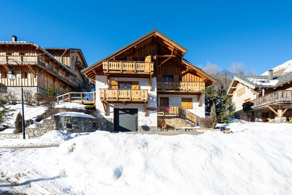 a house with a balcony in the snow at Chalet au bois joli in Valloire