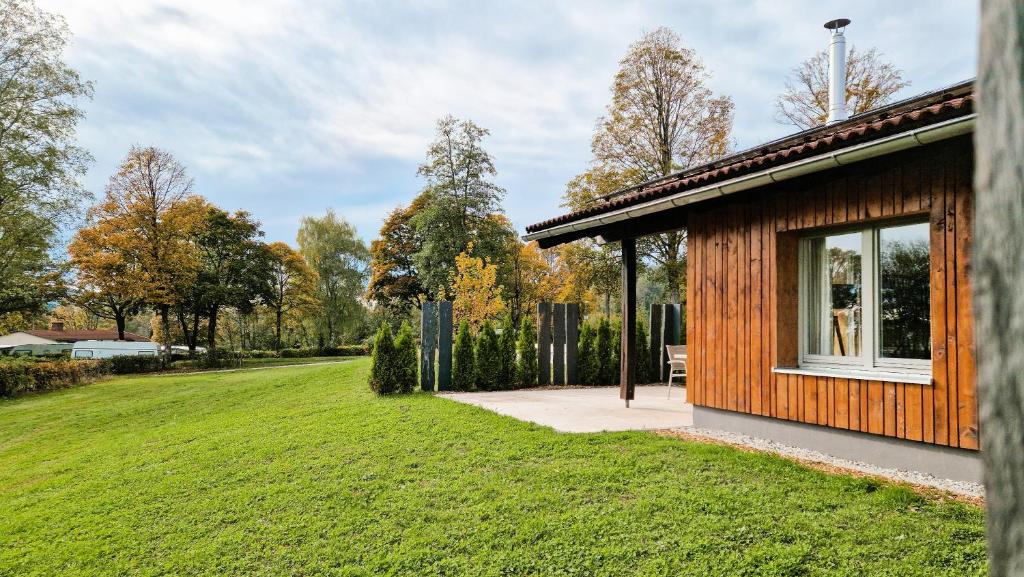 a wooden cabin with a window on a grass field at Franz Josefs Wald-Chalets in Untergriesbach