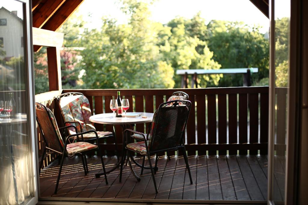 a patio with a table and chairs on a deck at Ferienhaus Gleissbuck in Schönbronn