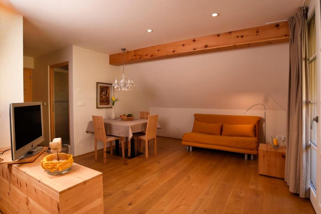 a living room with a couch a table and a television at Rosengartnerhof Apt Vorberg in Terlano