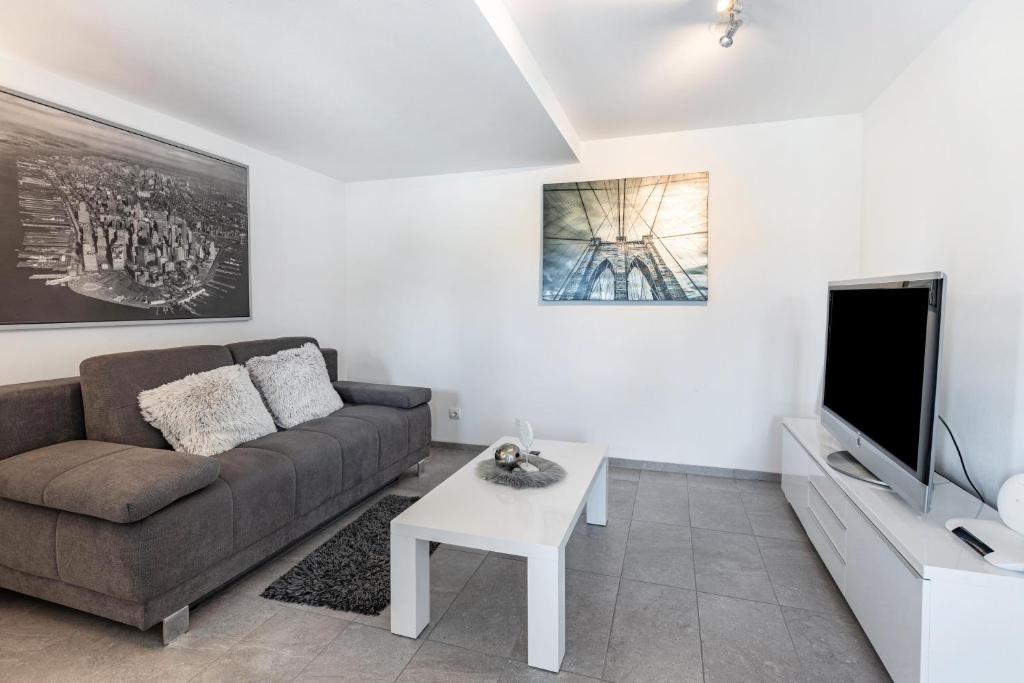 a living room with a couch and a tv at Schmuckstückchen in Hilzingen