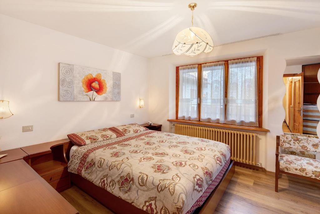 a bedroom with a bed and a table and a window at A Due Passi Valdidentro in Valdidentro
