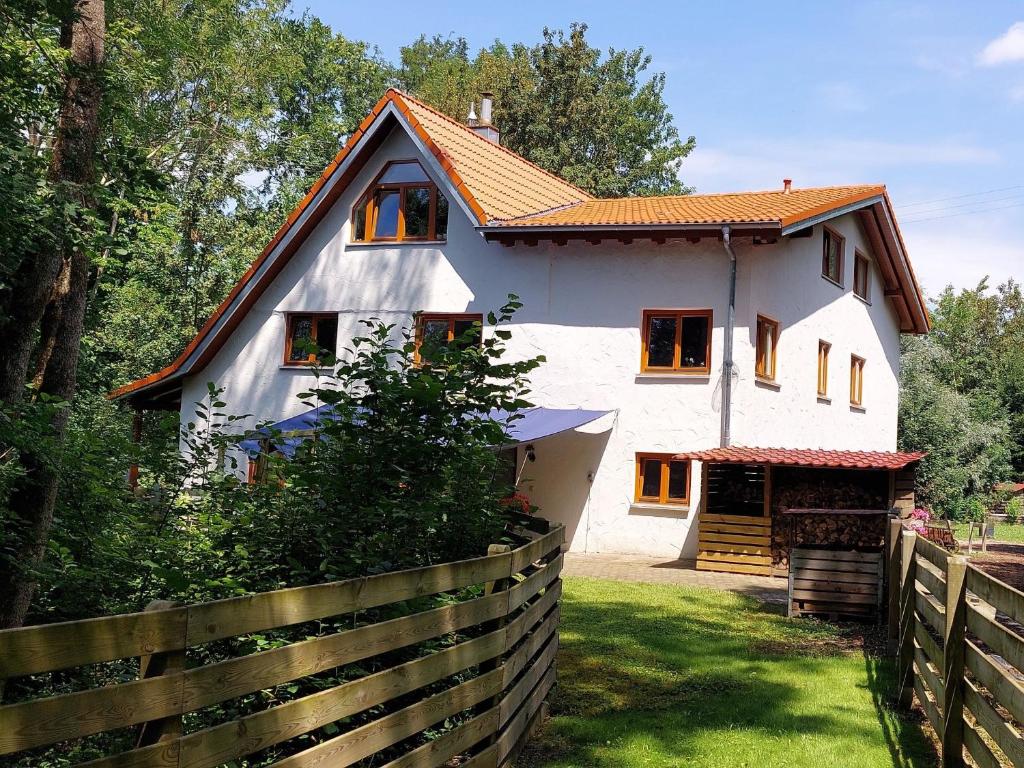 a white house with a fence in front of it at Ferienwohnung, offenes Apartment in Mochenwangen