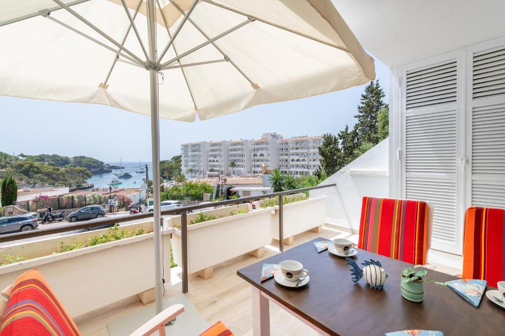 a balcony with a table and an umbrella at Apartamento Ola de Mar in Felanitx