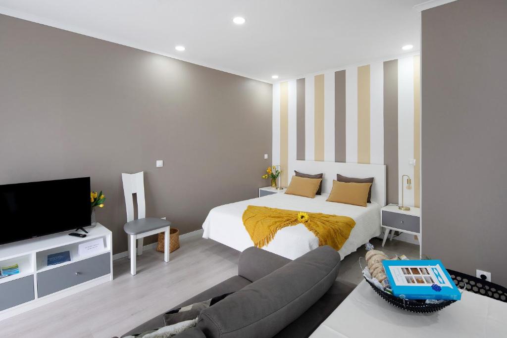 a bedroom with a bed and a couch at 58 Studio in Ribeira Grande