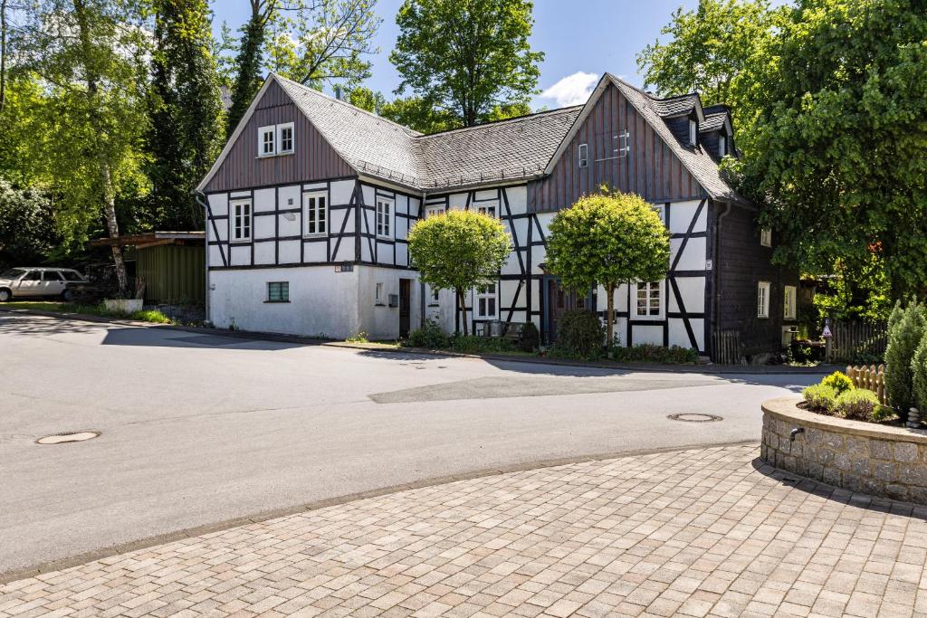a large black and white house with a driveway at Haus Berlar in Bestwig