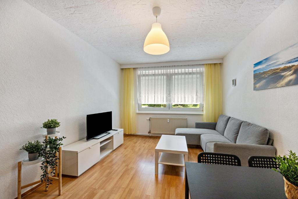 a living room with a couch and a tv at Wohnung am Geiseltalsee in Mücheln