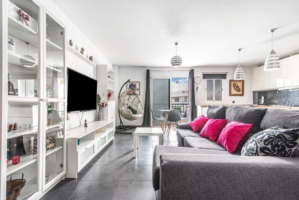a living room with a gray couch and pink pillows at Bright in Agaete