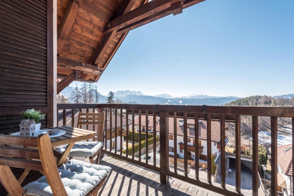 a deck with a table and chairs on a house at Apartment Vigl Lodge in Collalbo