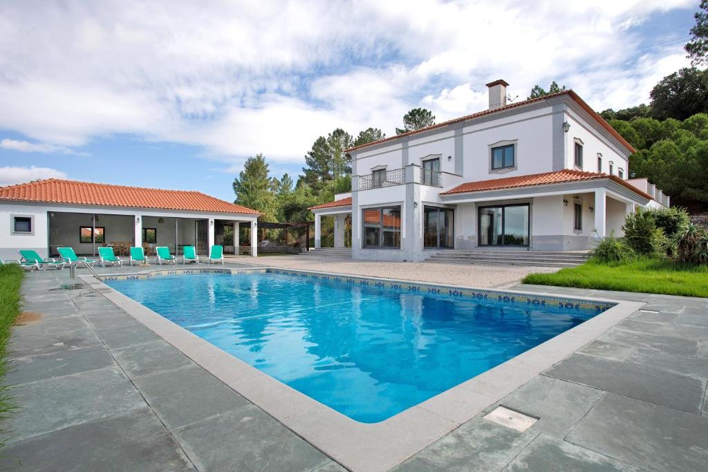 a house with a swimming pool in front of a house at Quinta Vale do Tejo in Chamusca