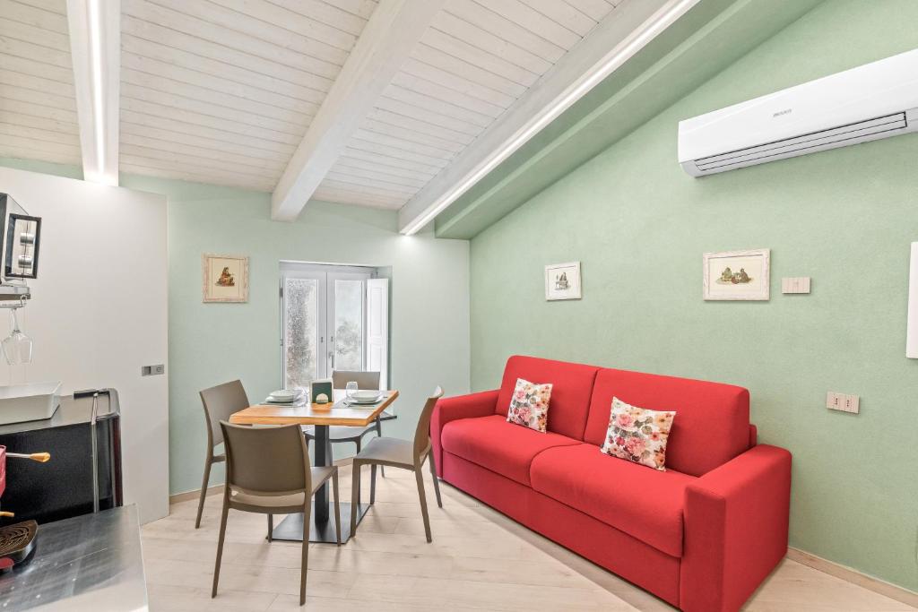 a living room with a red couch and a table at Residenza Borgo Antico Lucia in Ascea