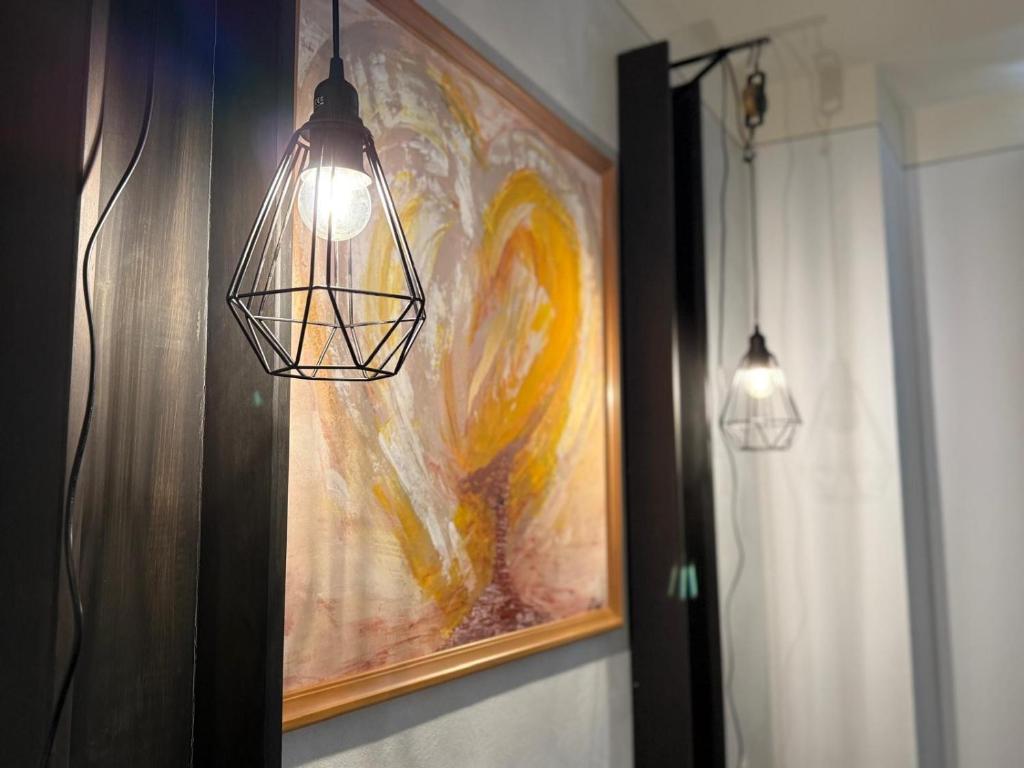 a bathroom with two lights and a painting on the wall at Appartement Neunkirchen City in Neunkirchen