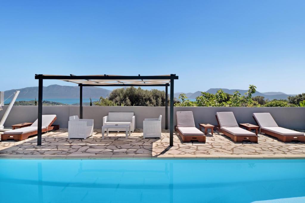 eine Gruppe von Stühlen und ein Schwimmbecken in der Unterkunft Villa Jimmy's Katomeri 2 in Meganisi