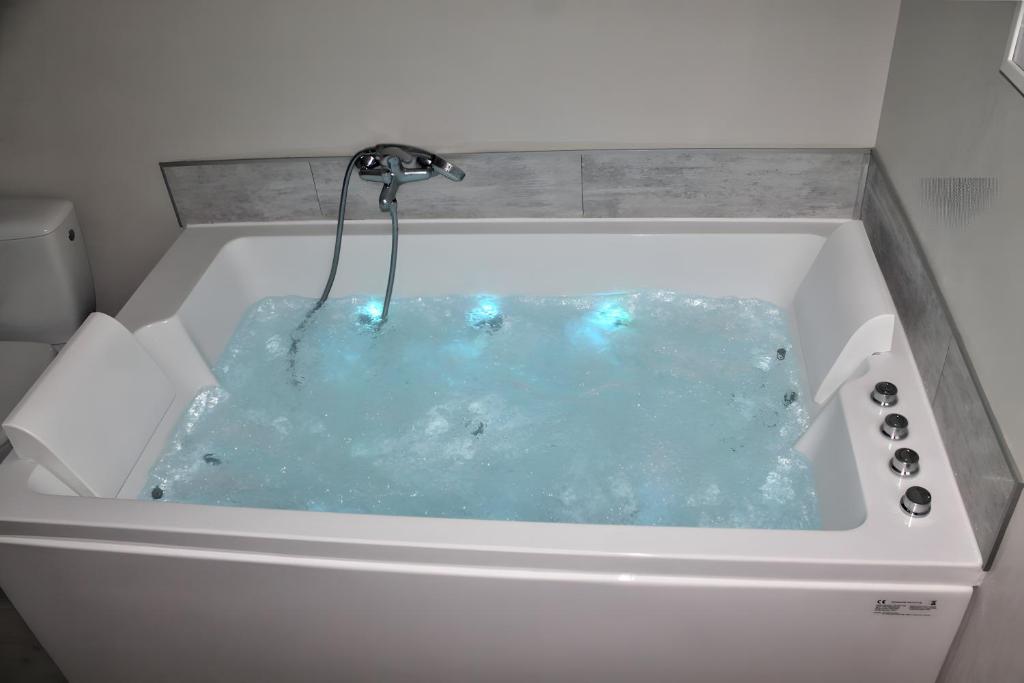 a bath tub filled with blue water at Gite Cocon et Balnéo in Selles-sur-Cher