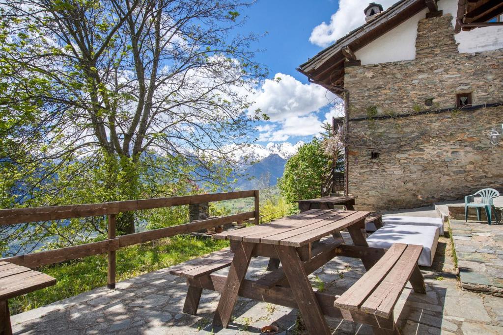 a wooden picnic table with a view of a mountain at Agriturismo Les Ecureuils in Saint-Pierre