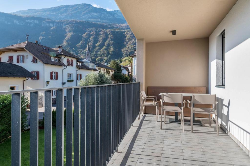 a balcony of a house with a table and chairs at Ferienwohnungen Karin - Golden in Termeno