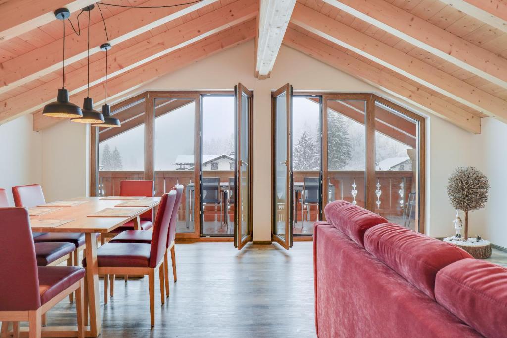 a dining room with a table and a red couch at Ferienwohnung Partnachklamm in Garmisch-Partenkirchen