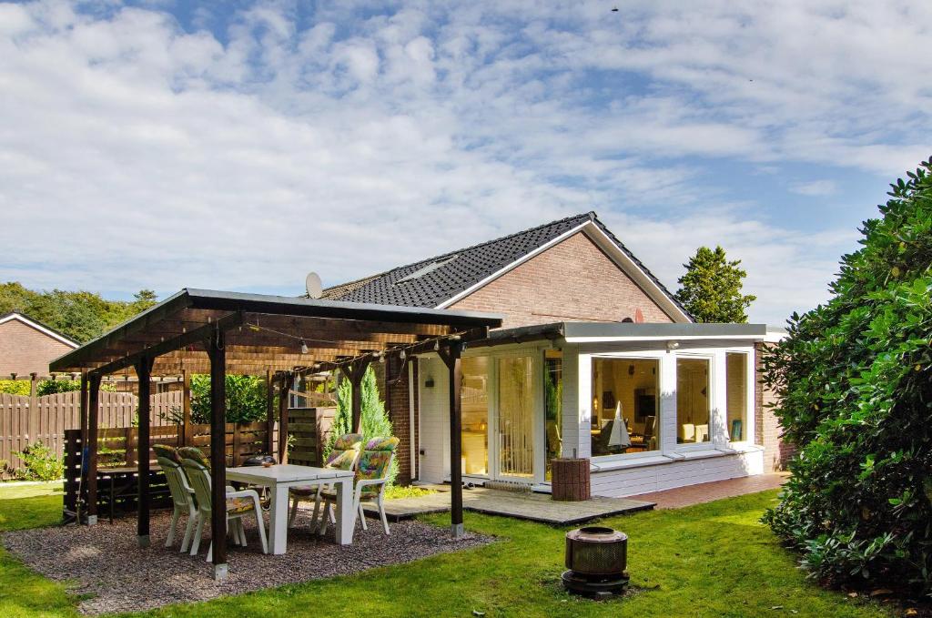 a house with a covered patio with a table and chairs at Ferienhaus Piet in Berumbur