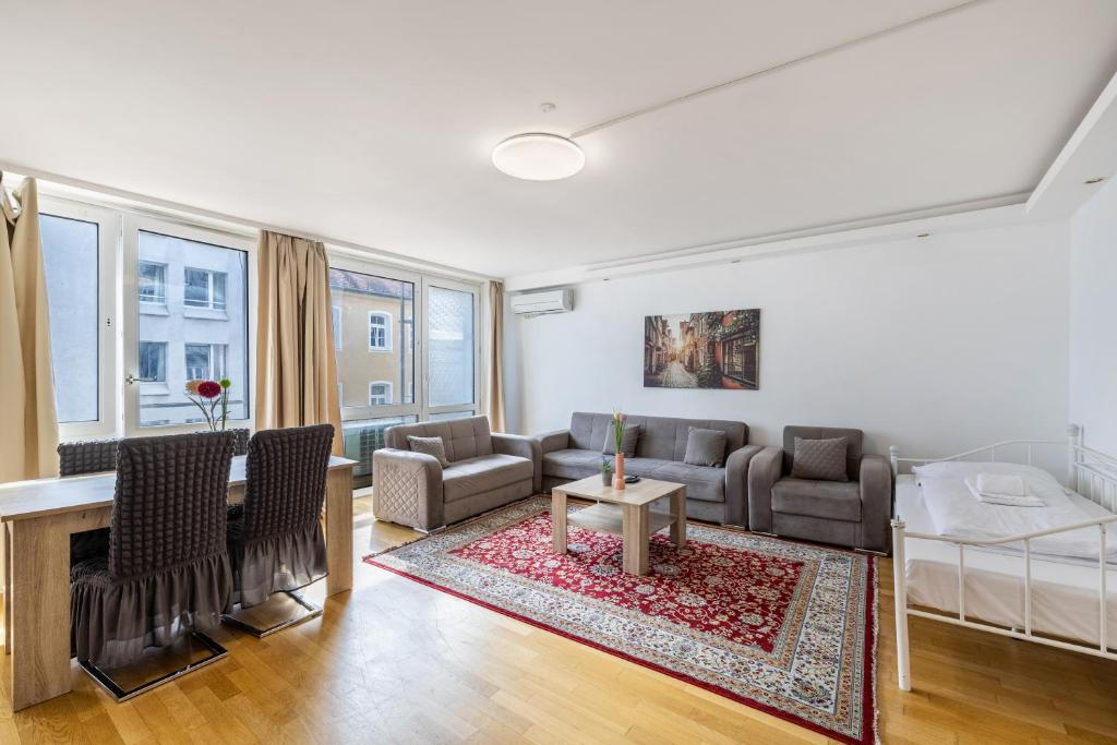 a living room with a couch and a table at Aldars Urban Trio Suite No.6 in Munich