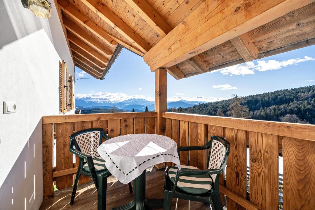 a table and chairs on a balcony with a view at Wohnung Arnika Stücklhof in San Genesio Atesino