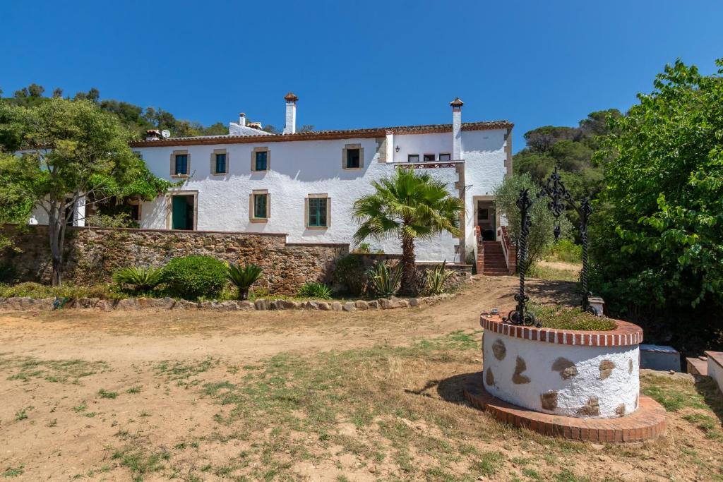 a house with a palm tree in front of it at Masía Can Garriga, Casa Gran in Girona