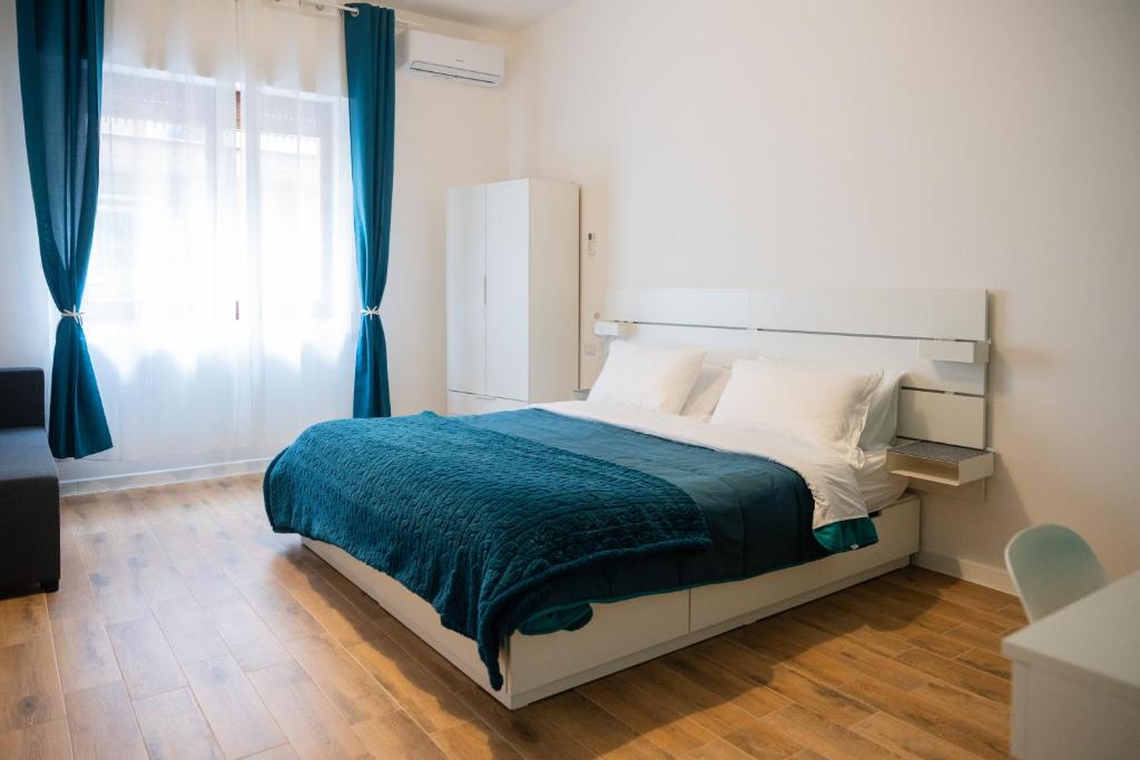 a bedroom with a large bed with a blue blanket at Oltremare in Molfetta