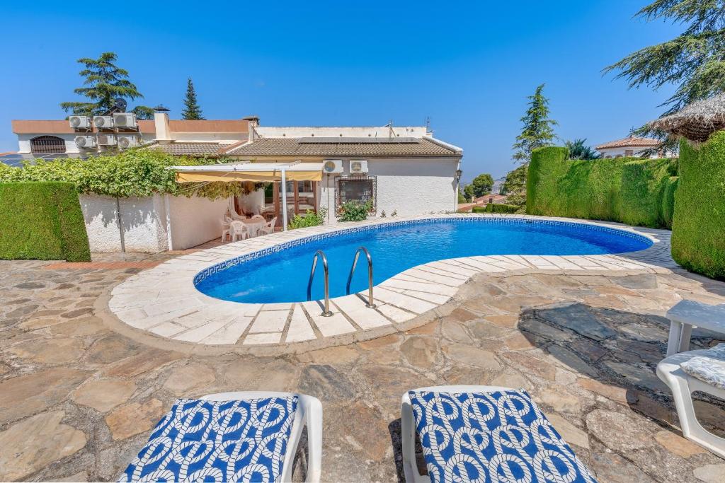 a swimming pool with surfboards in the middle at Villa Leonor con piscina privada in Monachil
