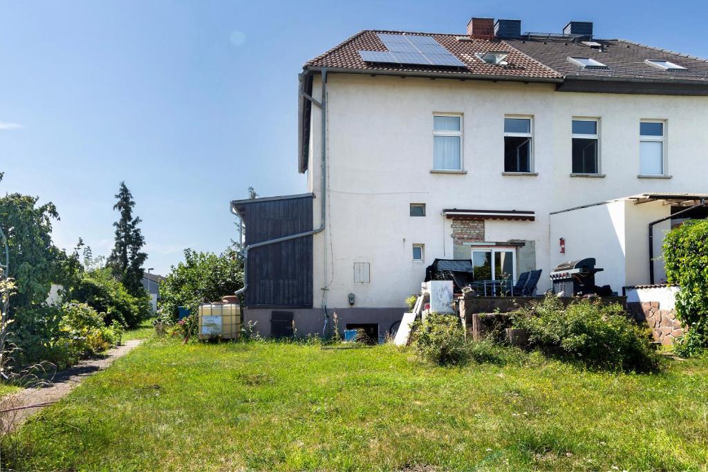 a white house with a green yard in front of it at Ferienwohnung Birgit in Dessau