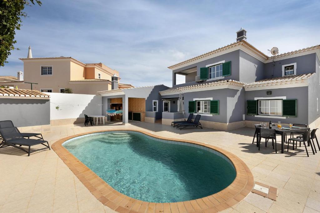 a villa with a swimming pool in front of a house at Villa Delphin in Lagos